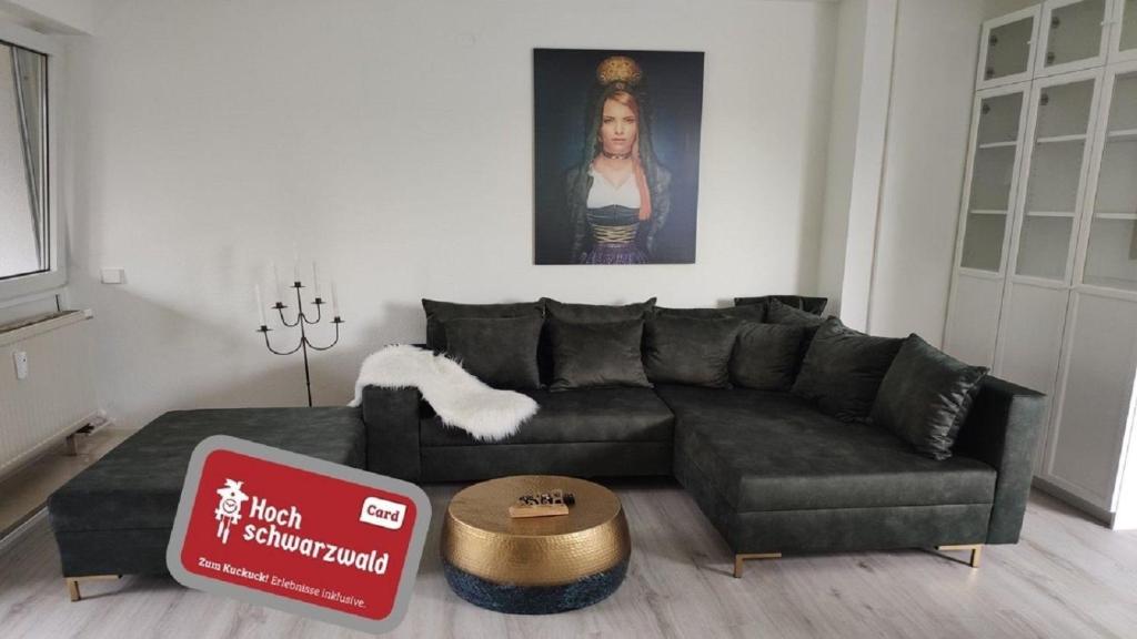 a living room with a black couch and a table at Romantik Ferienwohnung Bollenhut Superior in Lenzkirch