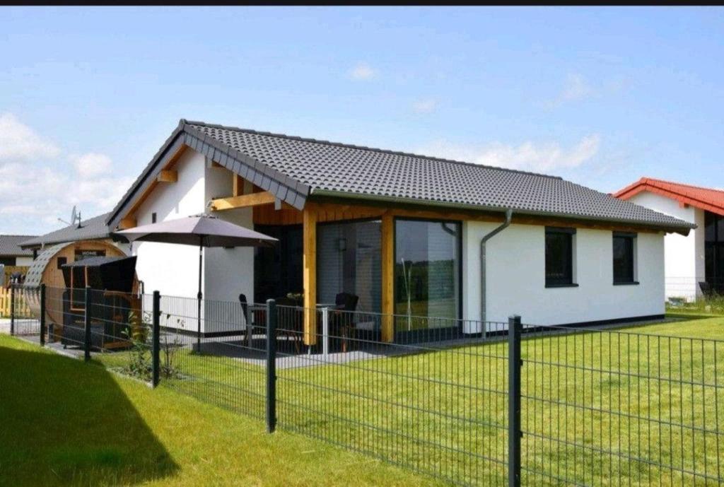 a white house with a fence in front of it at G7 Haus mit Blick ins Landschaftsschutzgebiet in Großwürden