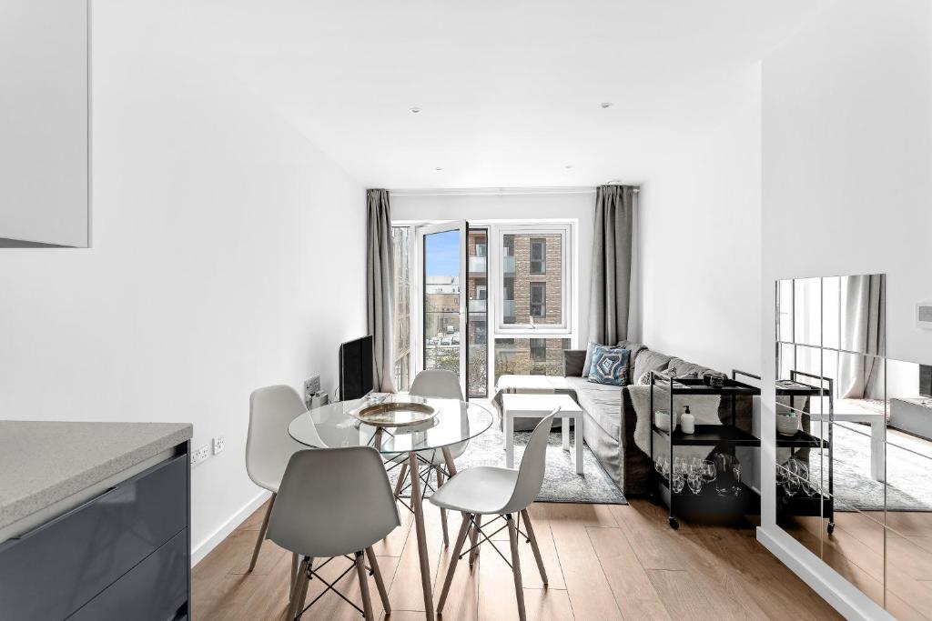 a white living room with a table and chairs at Stylish Flat In Battersea Reach in London