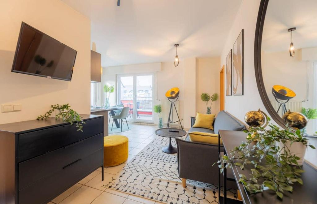 - un salon avec un canapé et une télévision dans l'établissement Cozy 1BR Apartment in Esch-sur-Alzette, à Esch-sur-Alzette