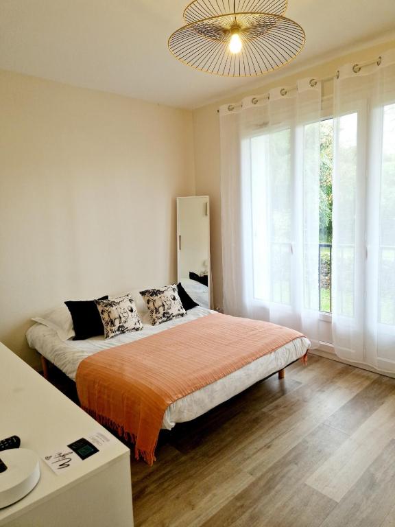 une chambre avec un lit et une grande fenêtre dans l'établissement Studio centre-ville au calme, à Espalion