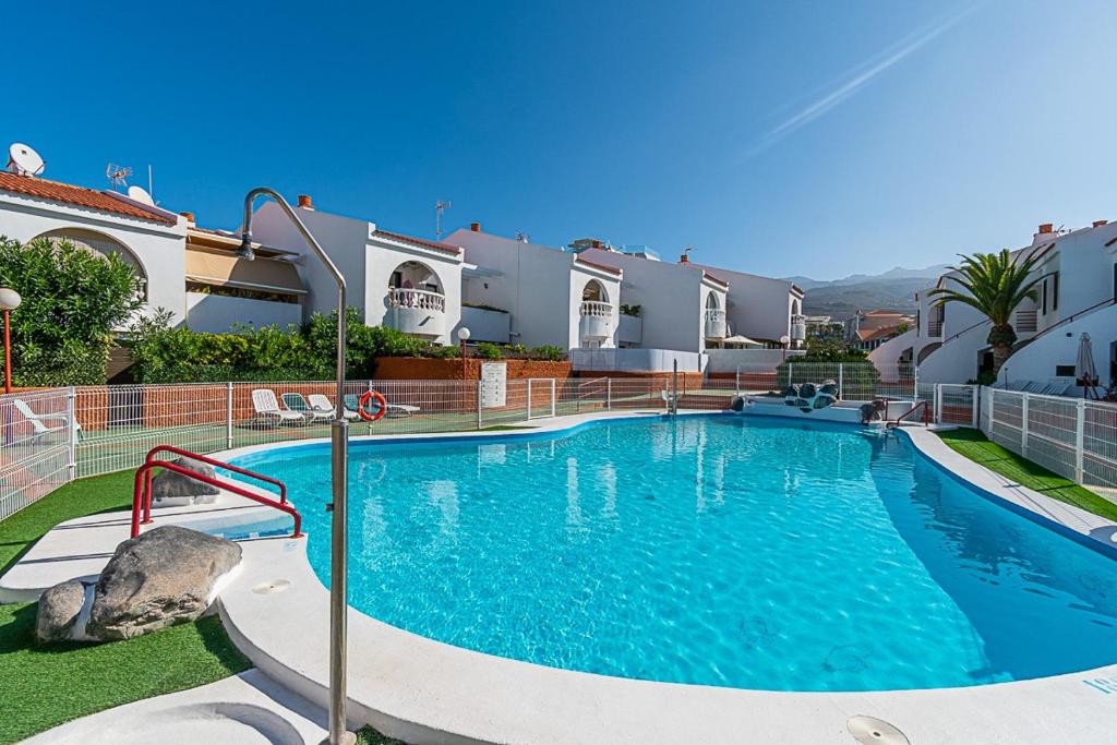 a large swimming pool in front of a house at Bungalow Paraiso in Callao Salvaje