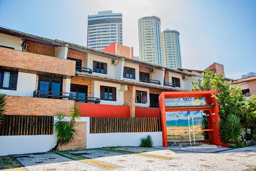 un edificio con una puerta roja delante de él en Garbos Soleil Hotel, en Natal