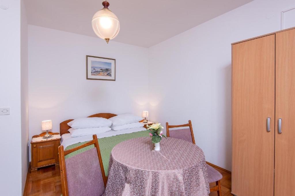 Cette petite chambre comprend une table et un lit. dans l'établissement Ferienwohnung für 2 Personen ca 30 qm in Viganj, Dalmatien Süddalmatien, à Viganj