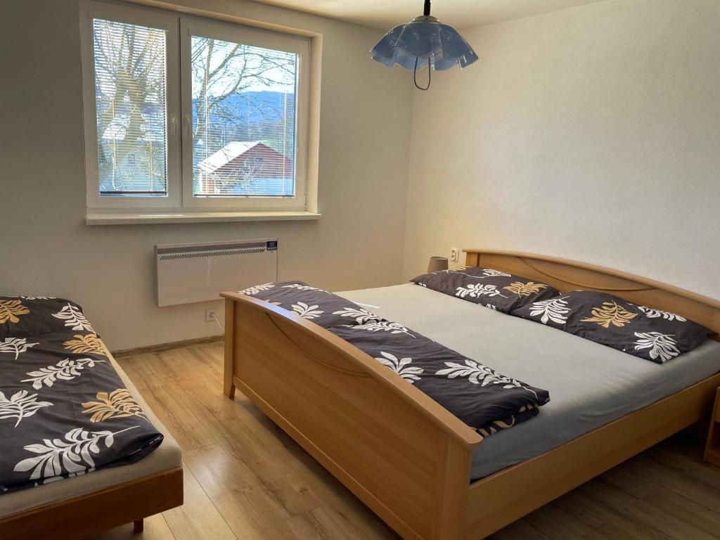 1 dormitorio con 2 camas y ventana en Ubytovanie u Aničky, 