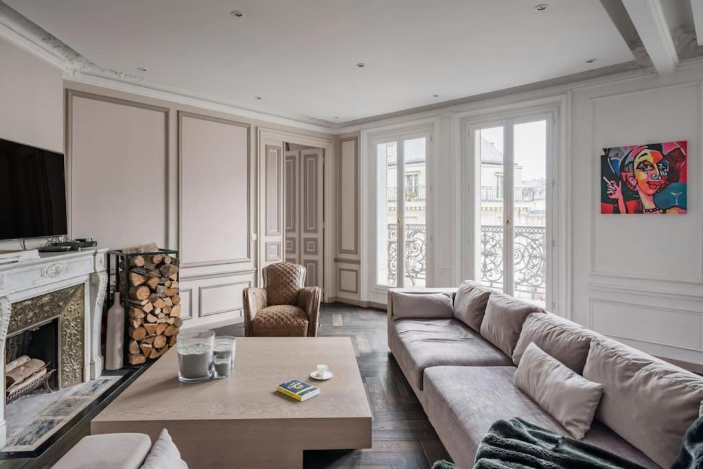 un salon avec un canapé et une cheminée dans l'établissement Resplendent Haussmann Design 100m2 - 2 BR, à Paris
