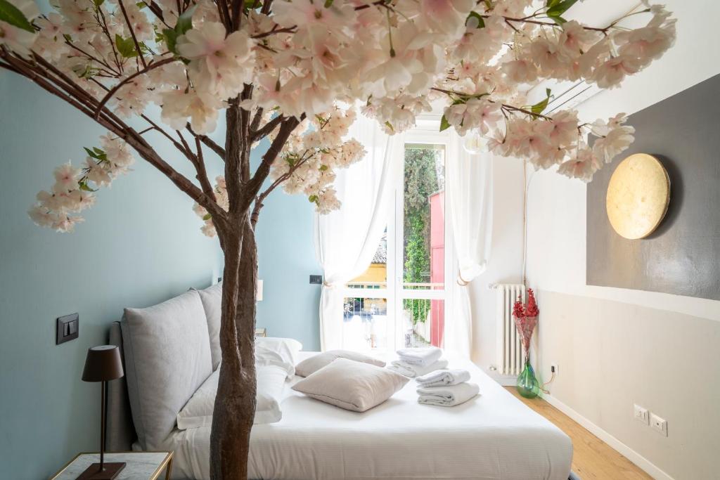 a bedroom with a tree with pink flowers on a bed at The cherry tree house in Florence