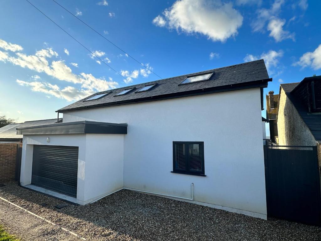 a white garage with a black roof at Tankerton Beach Daze in Kent