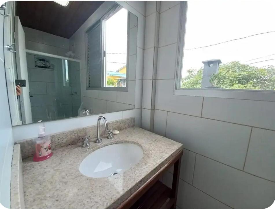 a bathroom with a sink and a mirror at Loft pé na areia in Florianópolis