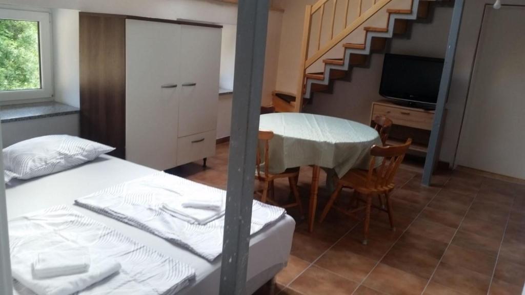 een slaapkamer met een bed, een tafel en een trap bij Ferienwohnung für 4 Personen ca 60 qm in Gozd, Krain Innerkrain in Gozd