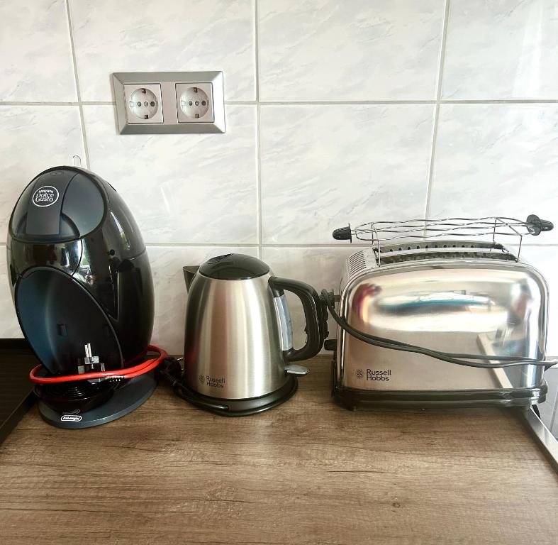 a kitchen counter with a toaster and a tea kettle at Großes Apartment mit Terrasse und Garten in Oberhaching
