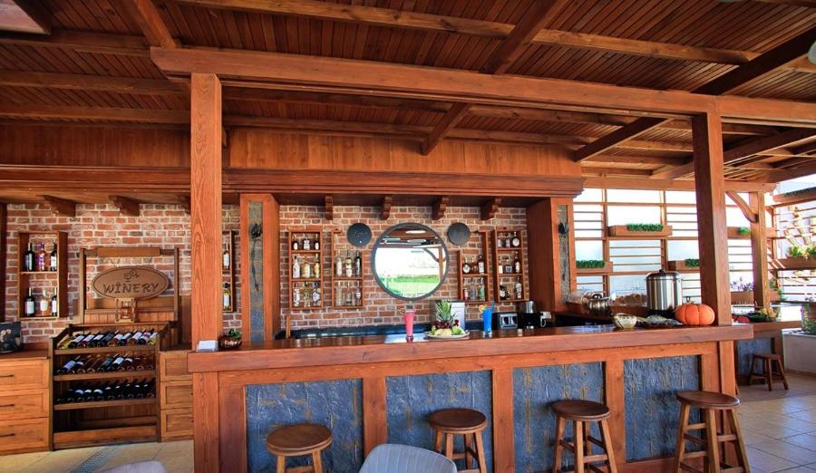 a bar with stools in a room with wooden walls at west coast boutique hotel in Bodrum City