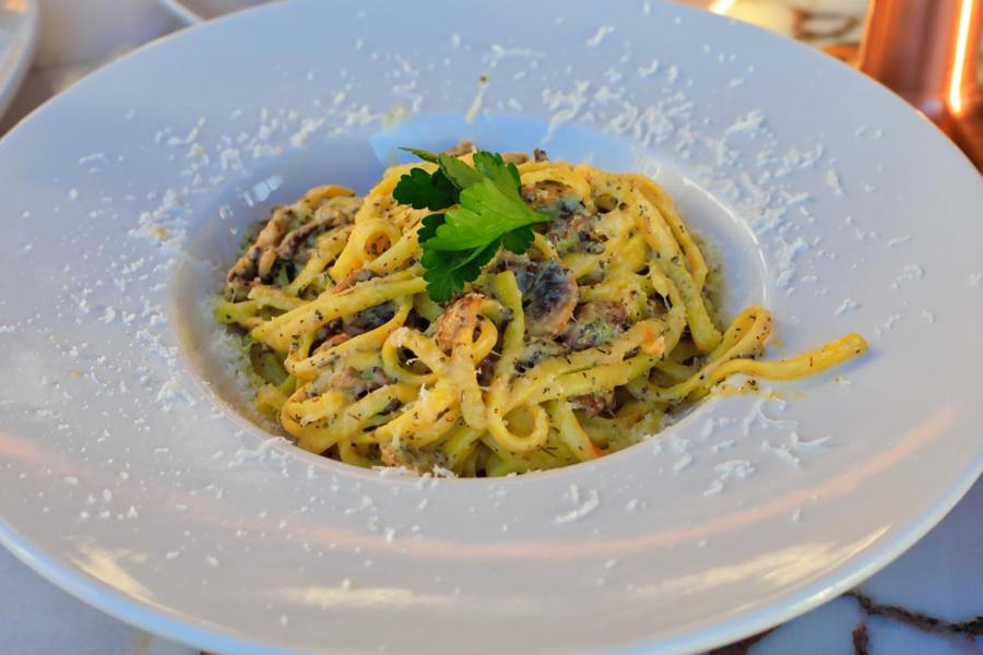 a white plate with pasta on a table at west coast boutique hotel in Bodrum City