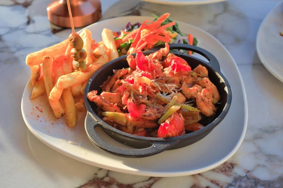 a bowl of food on a plate with french fries at west coast boutique hotel in Bodrum City