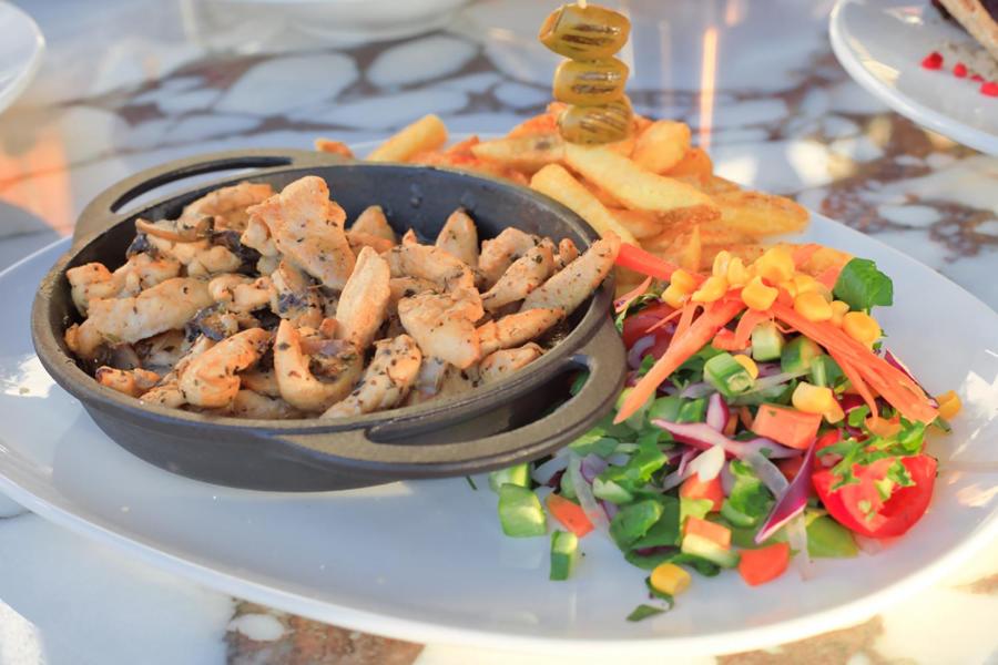 a plate with a bowl of food and a salad at west coast boutique hotel in Bodrum City