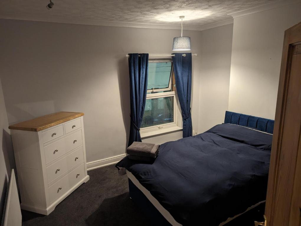 a bedroom with a bed and a dresser and a window at Spacious 2-Bed House in Newark in Newark-on-Trent