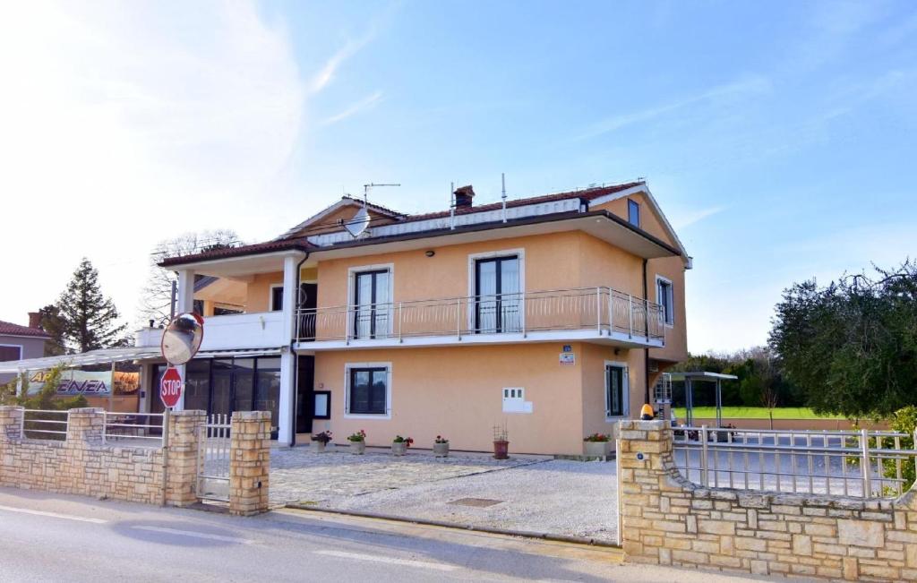 ein gelbes Haus mit einem Zaun davor in der Unterkunft Komfortable Wohnung in Savudrija mit Grill, Garten und Terrasse in Savudrija