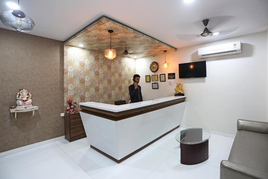 a man standing at a reception desk in a room at Super Capital O Hotel Swastika in Jaipur