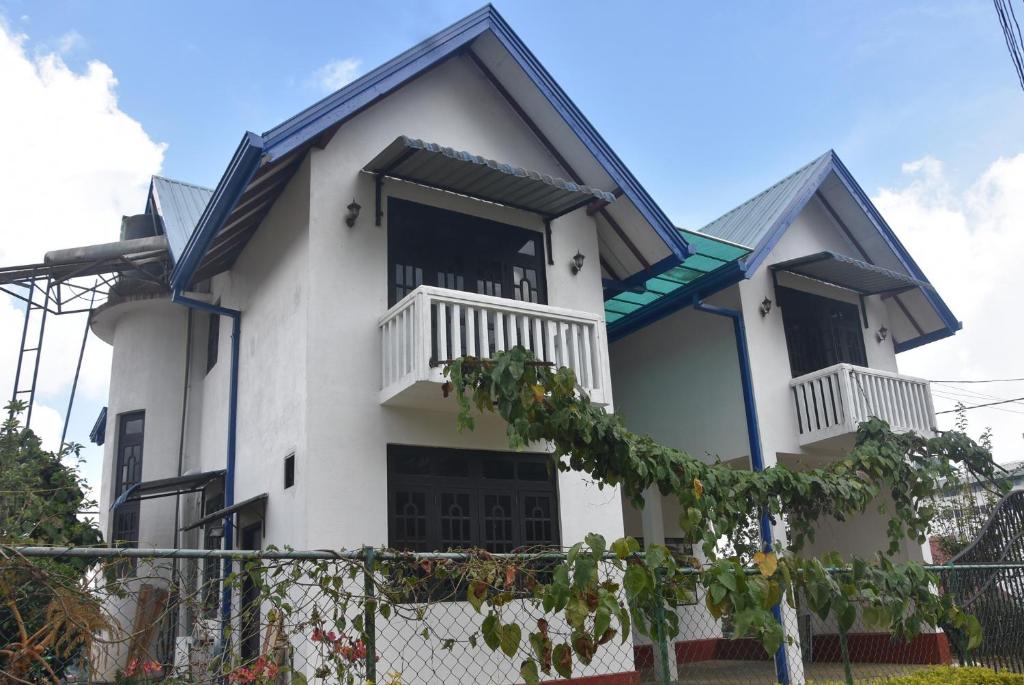 Casa blanca con techo azul en Birds Peak Hotel Nuwaraeliya, en Nuwara Eliya
