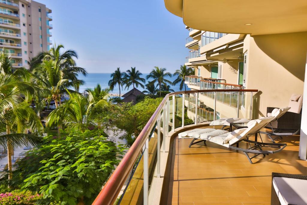 Un balcón con sillas y vista a la playa. en Departamento a pie de playa, en Nuevo Vallarta 