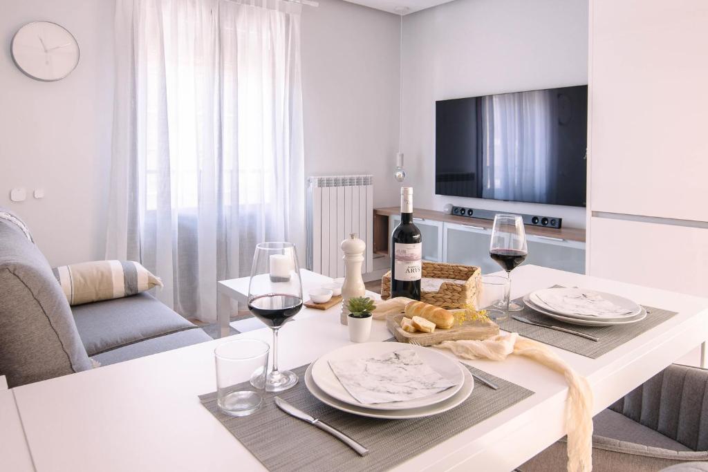 una sala de estar con una mesa con copas de vino en Apartamentos Casalarreina, en Casalarreina