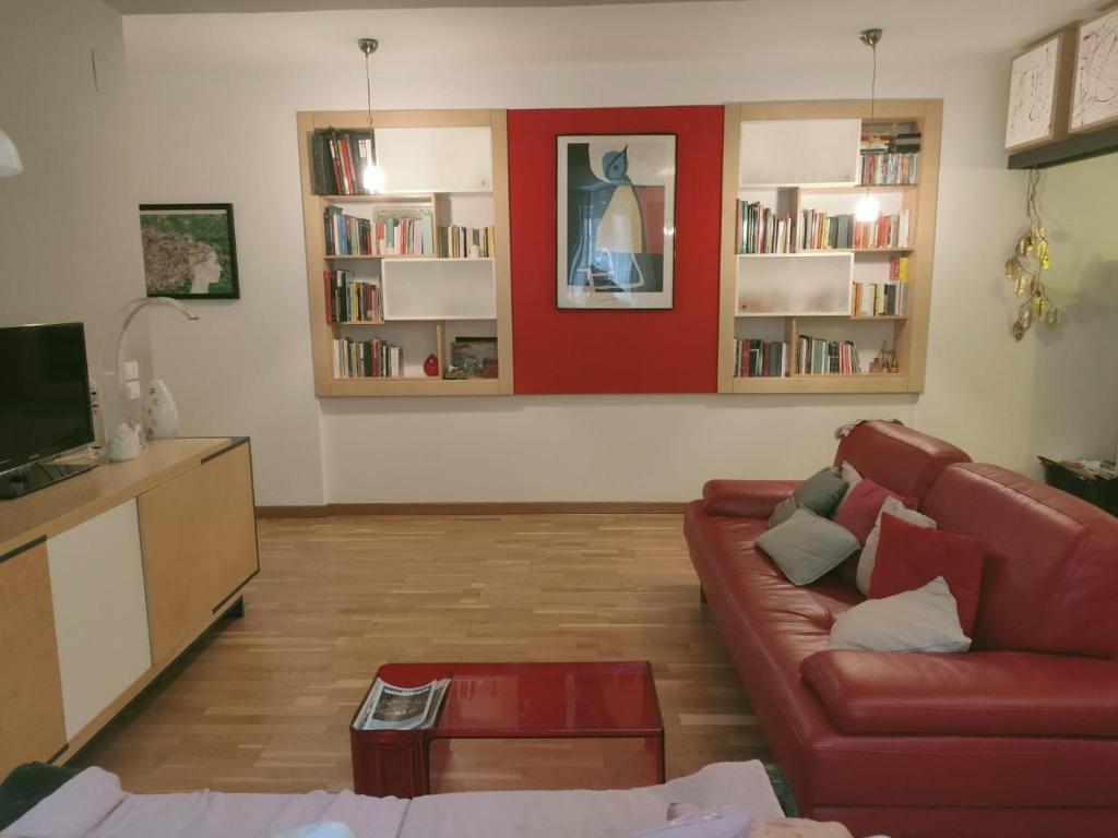een woonkamer met een rode muur en een bank bij Casa Anita In centro in Palermo