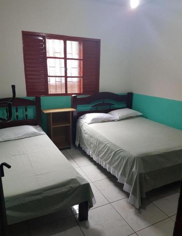 a room with two beds and a window at Pousada Econômica in Uberlândia