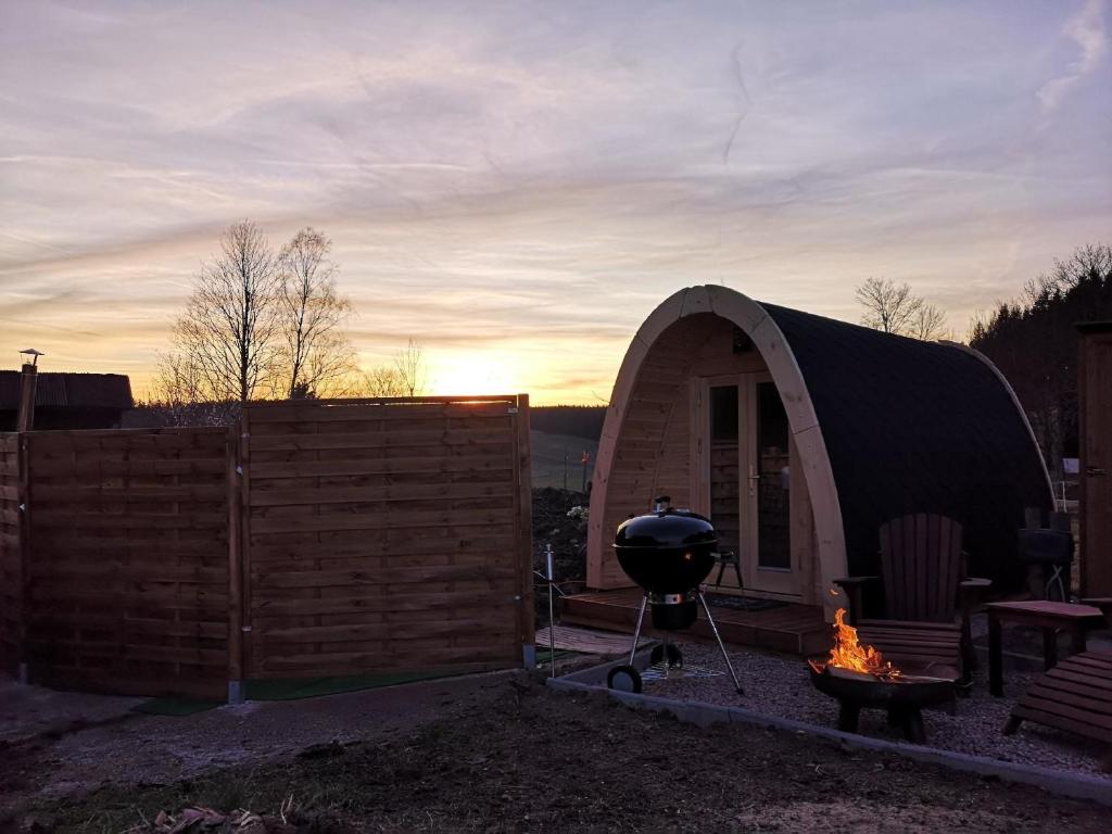 a dome tent with a grill in a backyard at Romantisches Holz-Iglu Optional mit Hotpot mit Whirlpoolfunktion und LED Unterwasserbeleuchtung in Neuhaus an der Eger