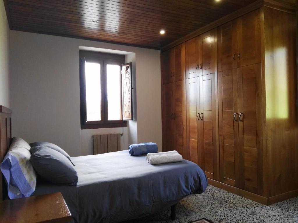 1 dormitorio con 1 cama y un gran armario de madera en CASA RURAL ACANTILADOS DE PAPEL, en Morás