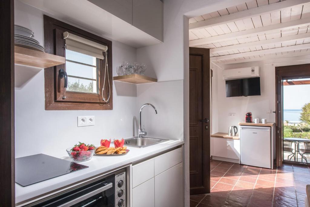 eine Küche mit Spüle und eine Schale mit Obst auf der Theke in der Unterkunft Little Seaside Villa in Hersonissos in Hersonissos