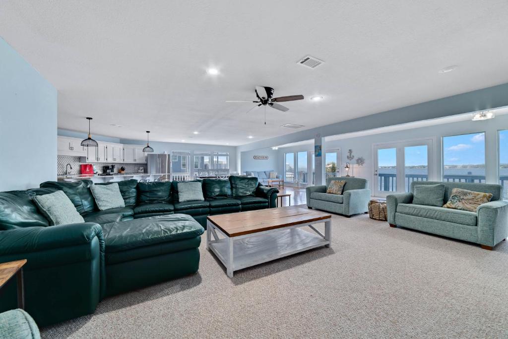 ein Wohnzimmer mit Sofa, Stühlen und einem Tisch in der Unterkunft Beach Energy in Gulf Shores