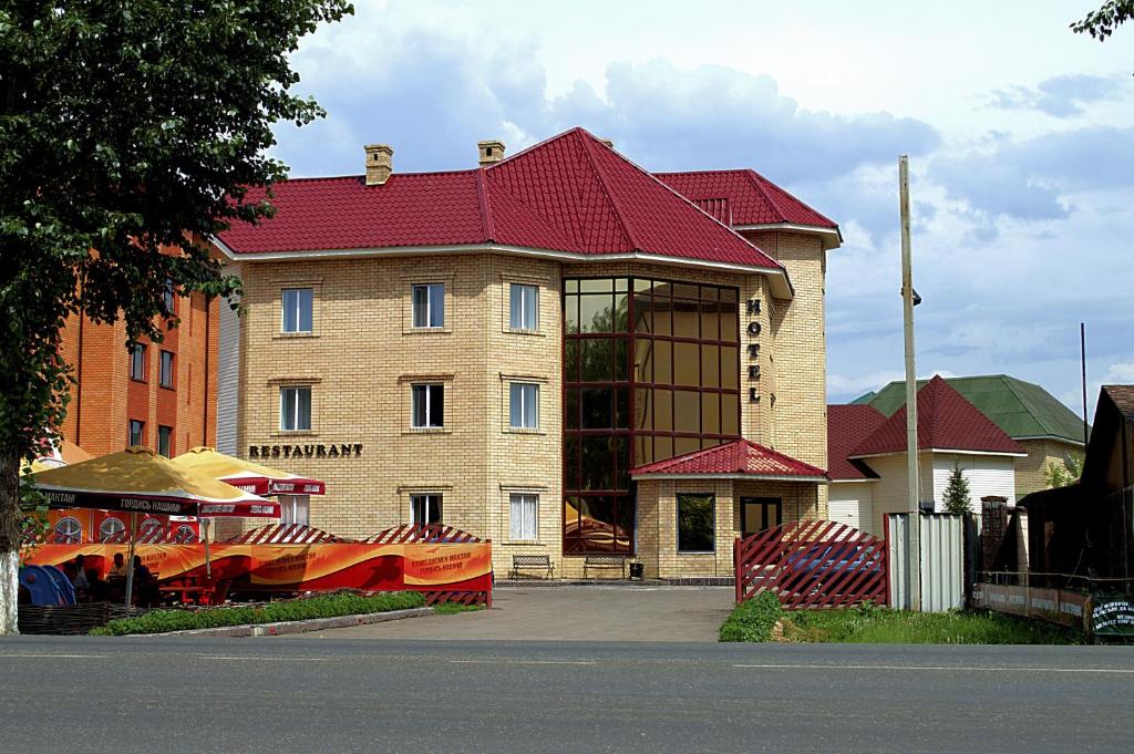 duży ceglany budynek z czerwonym dachem w obiekcie Hotel Gloria Standard w mieście Borowoje