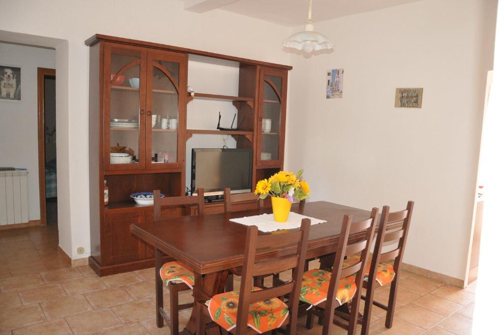 een eetkamer met een houten tafel en stoelen bij Poggio dei Venti in Monterotondo