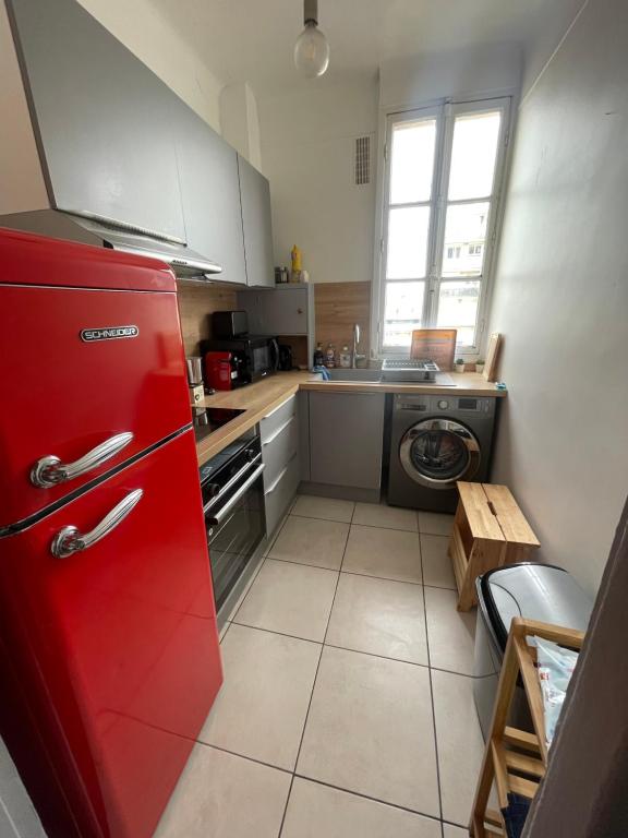 a kitchen with a red refrigerator and a washing machine at Profitez du calme de Courbevoie La Défense in Courbevoie