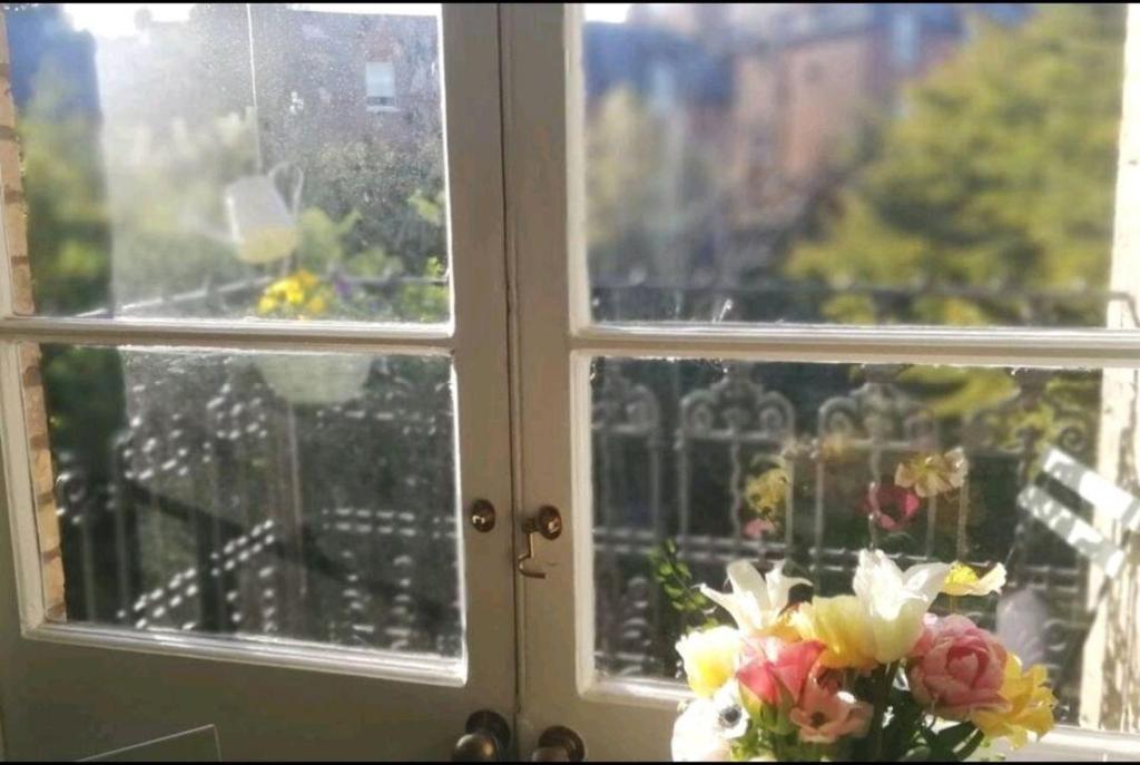 um vaso de flores sentado ao lado de uma janela em Ferienwohnung für 4 Personen ca 48 qm in London, England South East England em Londres