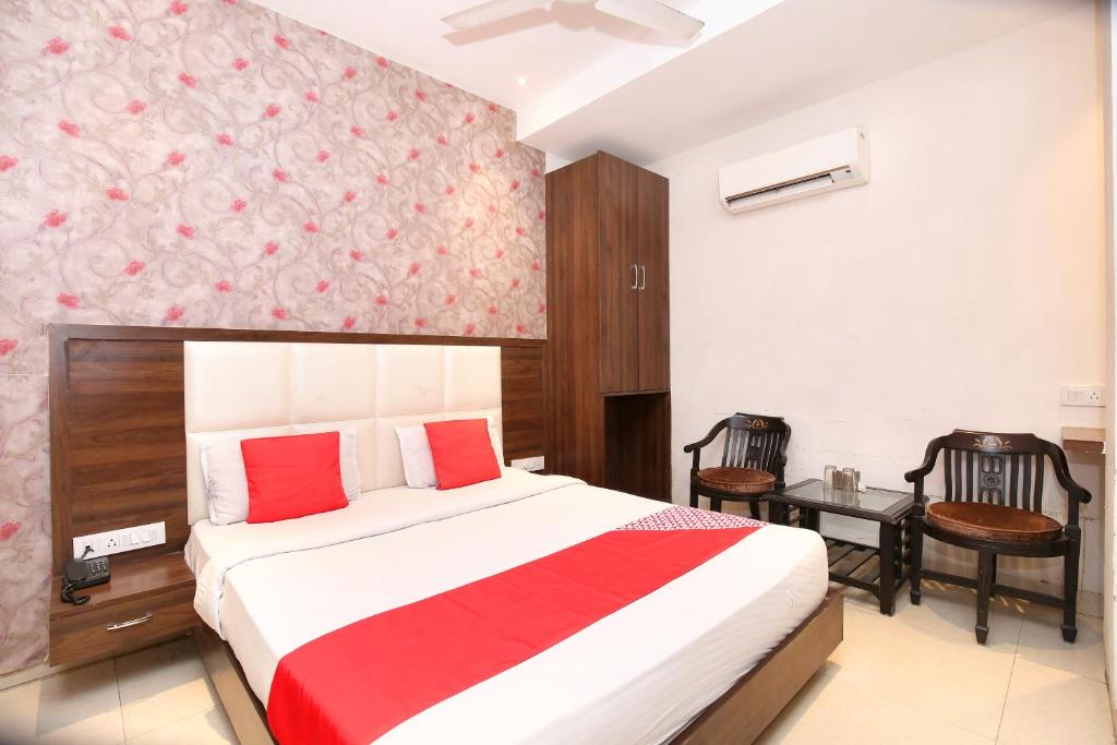 a bedroom with a bed with red and white sheets at Hotel Winner Inn in Amritsar