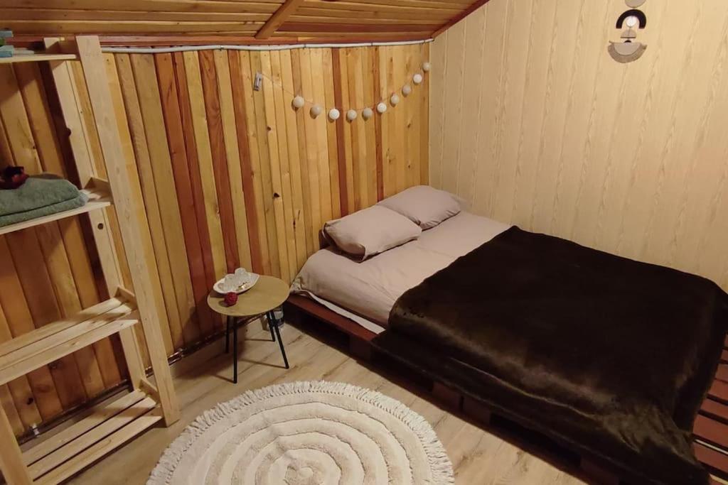 um pequeno quarto com uma cama e uma mesa em Moonlight Chalet Brasov em Codlea