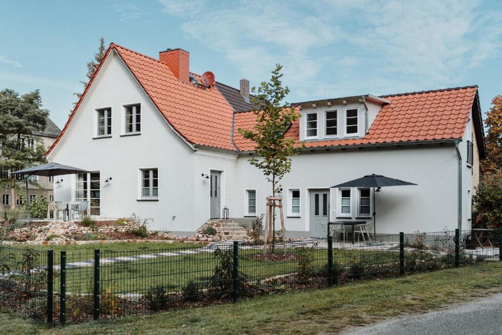 una casa blanca con techo naranja en Spreewaldhaus am Landgut - Das Haupthaus, en Markische Heide