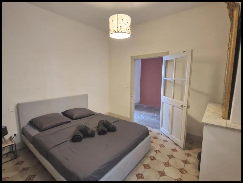 a bedroom with a bed with shoes on it at L'appartement des Arènes - Nîmes in Nîmes