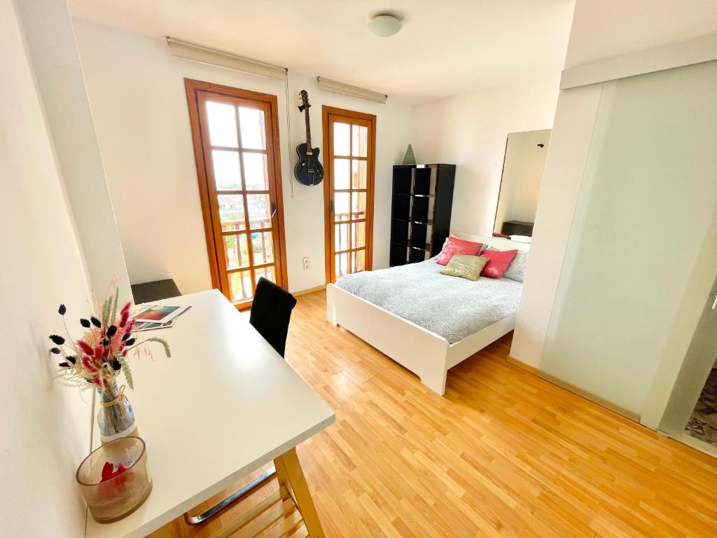 a bedroom with a bed and a table with a table sidx sidx at Ensuite Double Room with Sea View in a Shared Apartment in the Centre of Santa Eularia - close to the Beach in Santa Eularia des Riu