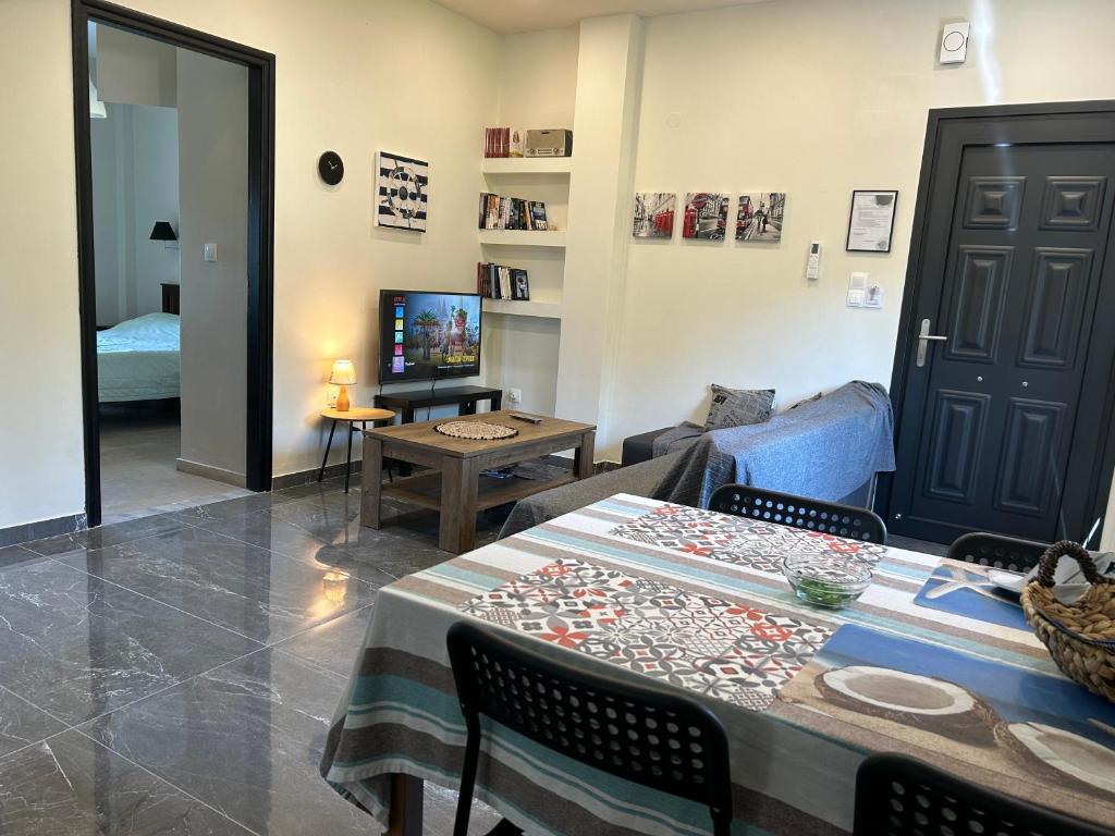 uma sala de estar com uma mesa e uma televisão em Alexander Apartments em Roda
