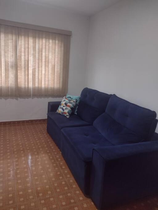 um sofá azul numa sala de estar com uma janela em Casa centro Itupeva hopii wet em Itupeva