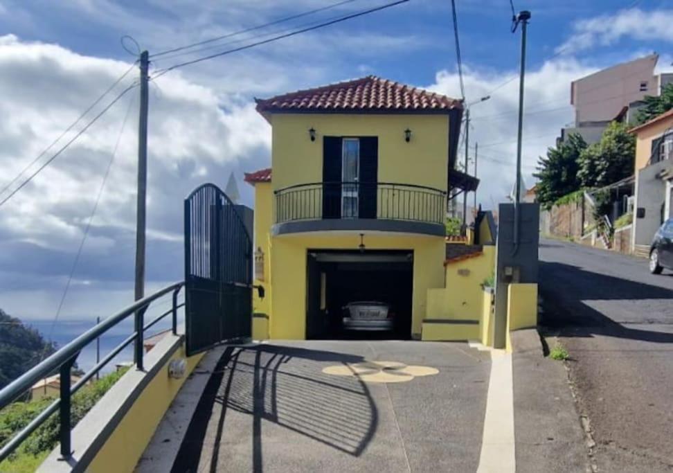a yellow house with a garage on the side of a road at casa sousa in Campanário