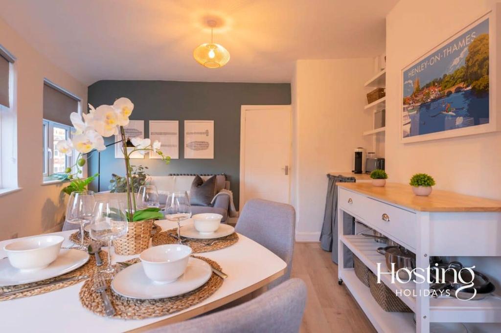 een eetkamer met een tafel met gerechten erop bij Stylish 2 Bedroom Apartment Close To The River & Station in Henley on Thames