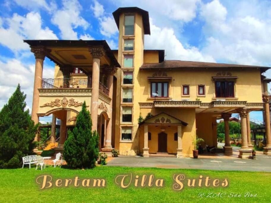 ein großes gelbes Gebäude mit einer Veranda und Säulen in der Unterkunft Bertam Villa Suites - Golf Resort by RZAC in Kepala Batas
