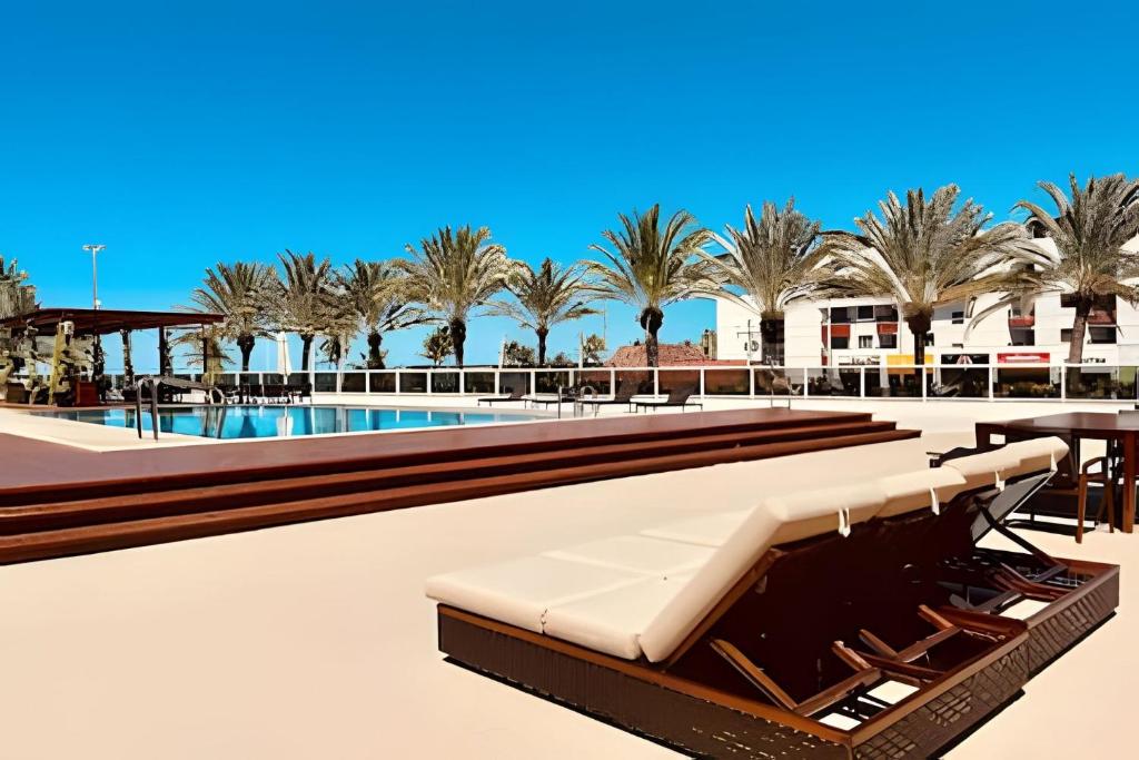 una piscina resort con bancos y palmeras en Luxo à beira-mar no Solar Tambaú, en João Pessoa