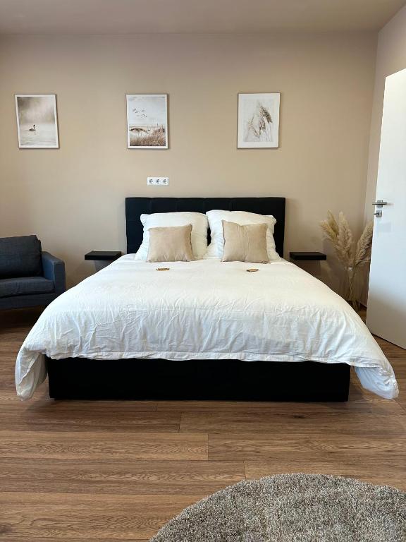 a bedroom with a large bed with two pillows at Modernes Apartment am Dreiländereck in Alsdorf