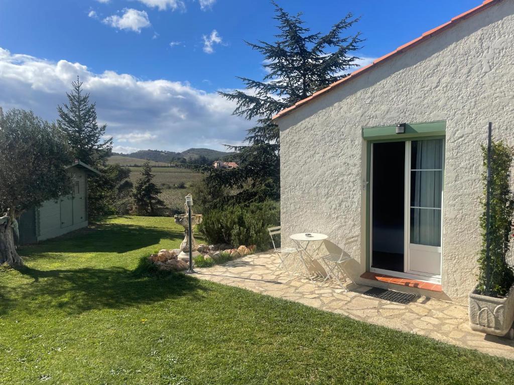 un edificio blanco con una puerta en un patio en la chambre de l'auxineill en Castelnou