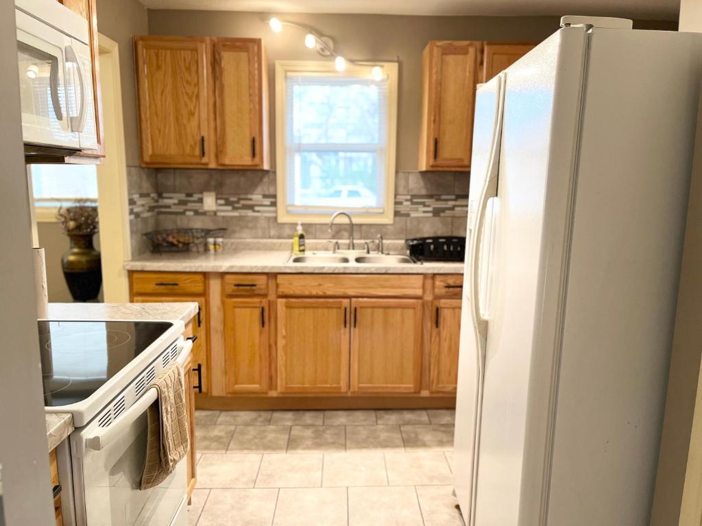 a kitchen with wooden cabinets and a white refrigerator at The Woodland Villa in Kansas City
