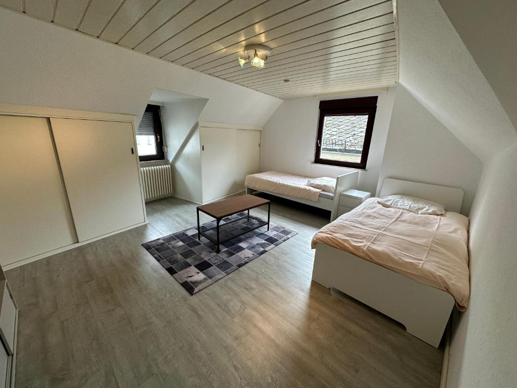 a bedroom with two beds and a table in it at Guest room - Monteurzimmer im Kestert (56348) in Kestert